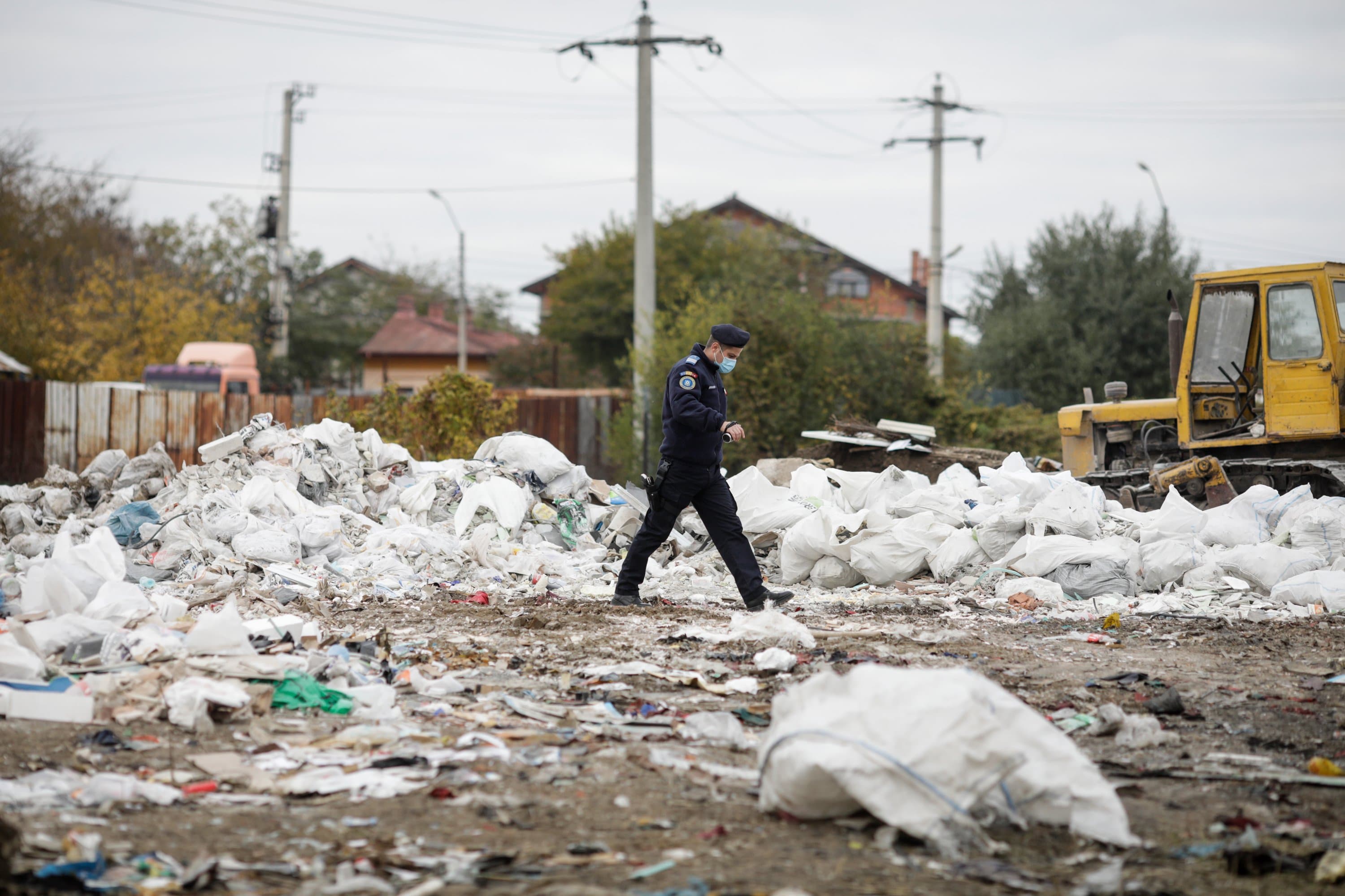 Policeman walking in waste field.