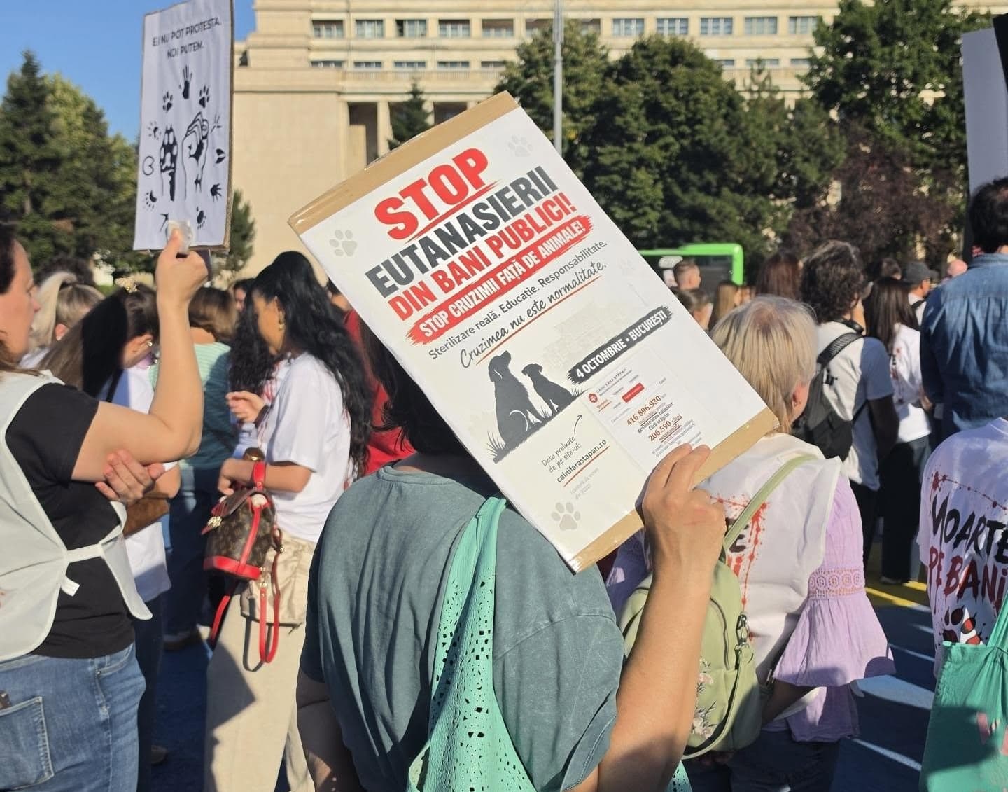 Woman holds 'stop euthanasia' sign at animal-rights march in Bucharest.